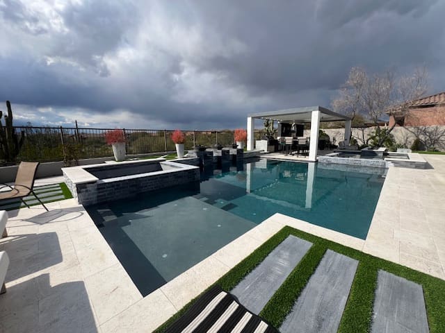 A pool with a large bench and chairs in it